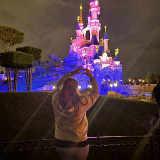 Fanny vor beleuchtetem Disneyschloss
