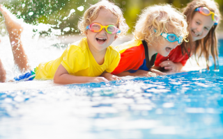 Kinder haben Spaß am Pool mit Taucherbrillen auf