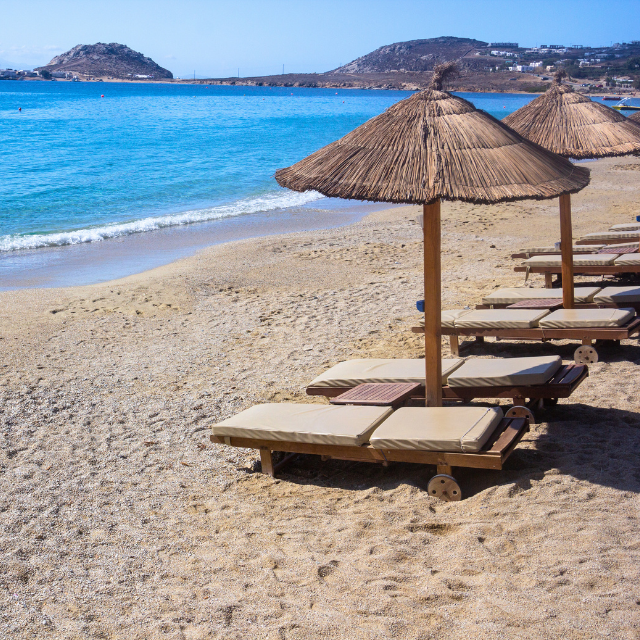 Strand mt Sonnenliegen und Strohschirmen