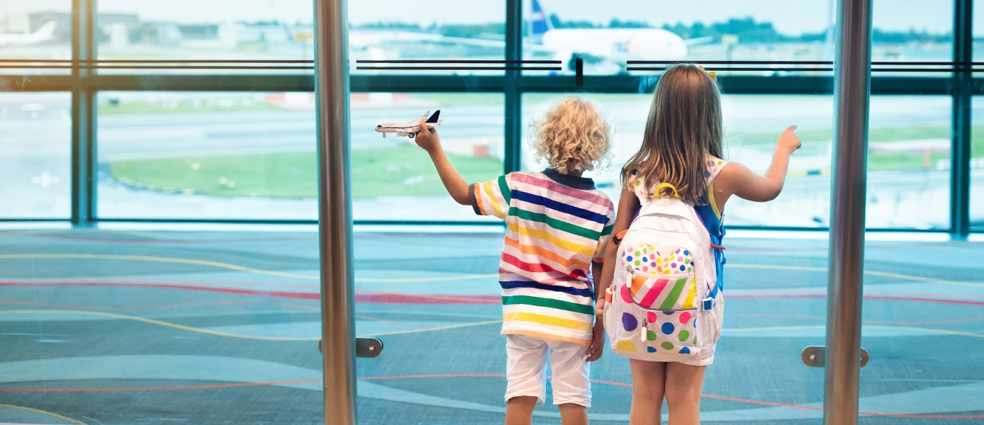 Kinder bestaunen vom Gate aus ein Flugzeug