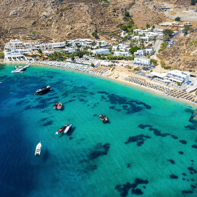 Luftaufnahme auf Psarou Beach mit Beachclubs im Hintergrund