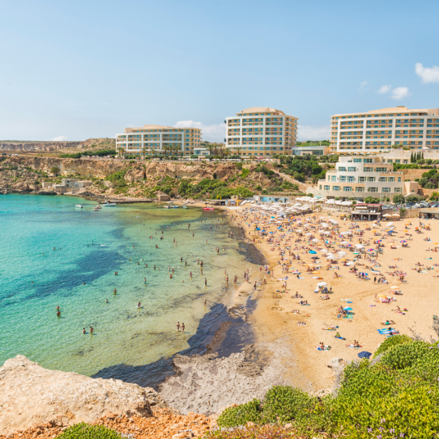 Blick von einer Klippe auf Golden Bay voller Leute
