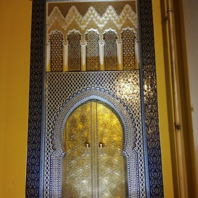 Prunkvolle goldene Eingangstür mit blaue-weißem Mosaik