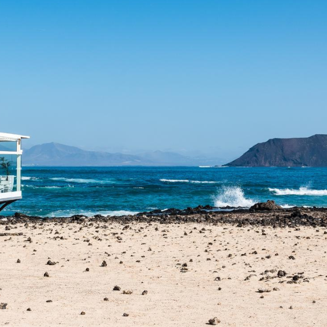 Heller Strand der Grandes Playas de Corralejo mit Restaurant Terasse im Vordergrund